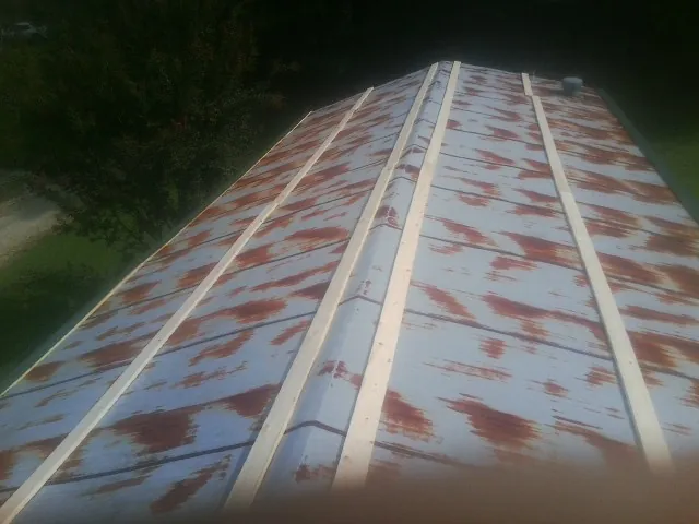 Rusted metal roof panels with new wood purlins before replacement — Storm Damage Roof Repair in Niota by Roofing Brothers